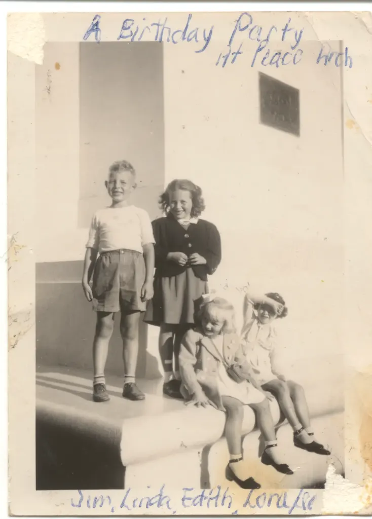 Four children on a stone ledge, captioned A Birthday Party at Peace Arch and named Jim, Linda, Edith and Lorraine in ink.