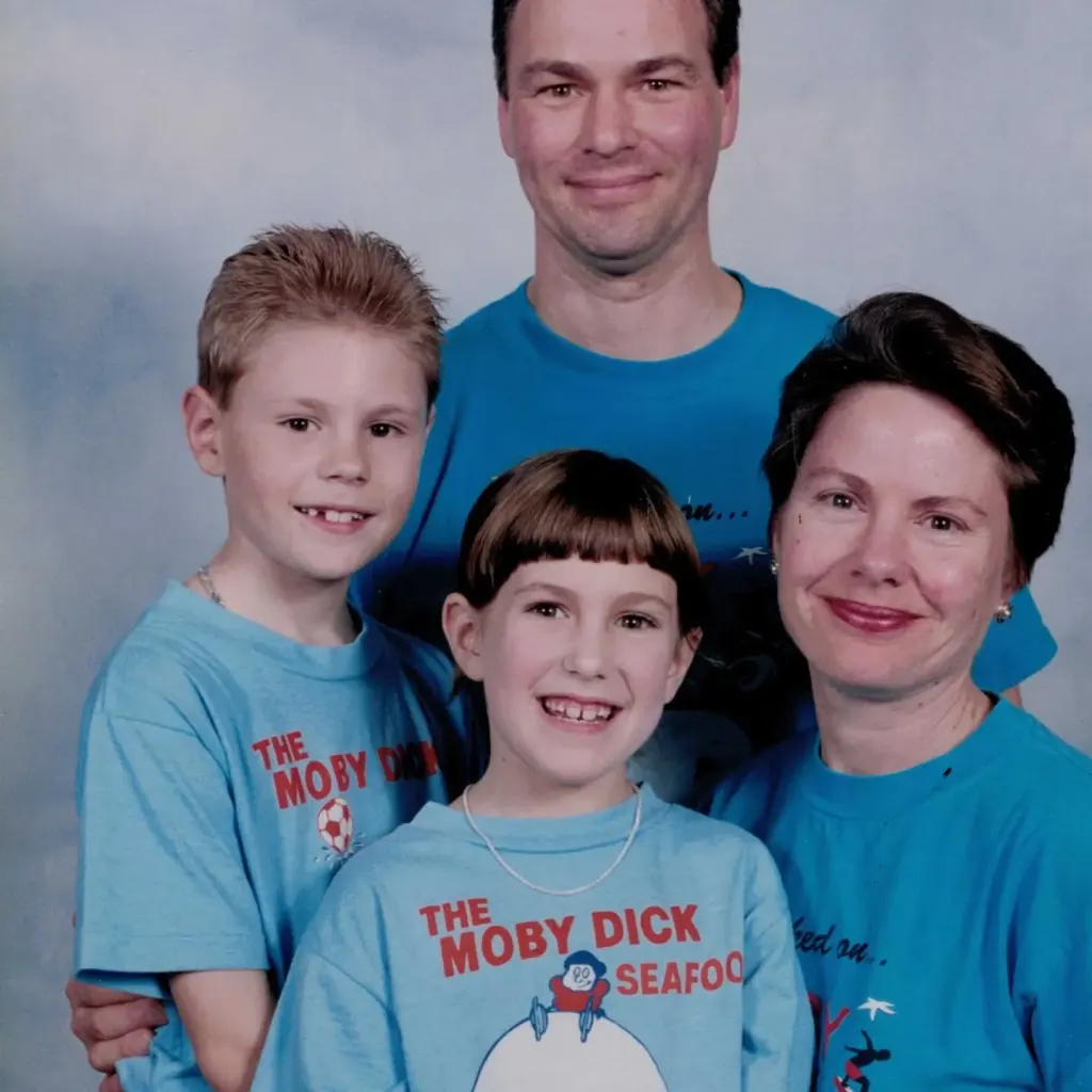 A portrait of a man, a woman, a boy and a girl in matching blue Moby Dick T-shirts.